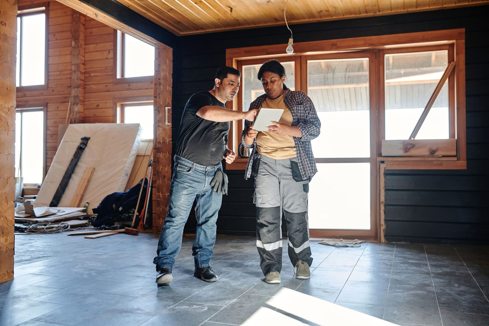 Zwei Handwerker stimmen sich im Innenausbau über Unterlagen ab.
